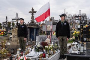 Pomnik, - historyczny grób bł. Rodziny Ulmów. Po bokach harcerki.