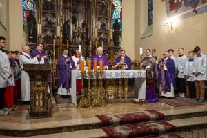 Księża odprawiający Mszę Świętą na tle ołtarza.