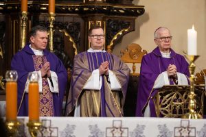 Księża odprawiający Mszę Świętą na tle ołtarza.