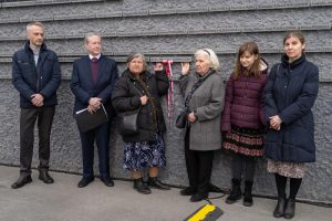 Grupa ludzi na tle Ściany Pamięci Muzeum Ulmów.