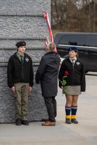 Grupa ludzi na tle Ściany Pamięci Muzeum Ulmów.