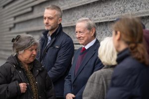 Grupa ludzi na tle Ściany Pamięci Muzeum Ulmów.