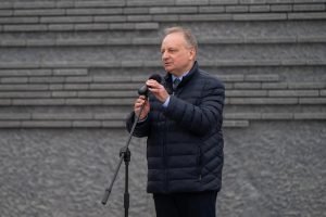 Prelegent przemawia przed Ścianą Pamięci Muzeum Ulmów.