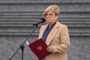 Prelegentka przemawia przed Ścianą Pamięci Muzeum Ulmów.