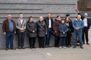 Grupa ludzi na tle Ściany Pamięci Muzeum Ulmów.