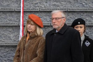 Grupa ludzi na tle Ściany Pamięci Muzeum Ulmów.