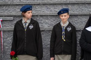 Dwie harcerki na tle Ściany Pamięci Muzeum Ulmów.