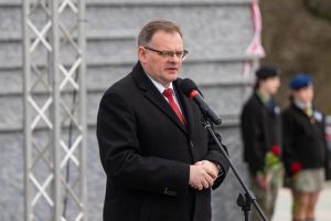 Prelegent przemawia przed Ścianą Pamięci Muzeum Ulmów.