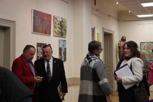 Zwiedzający na tle ekspozycji "Sługa Boży" w Muzeum Diecezjalnym w Rzeszowie.