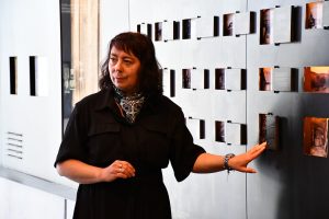 Przewodniczka muzealna na tle ekspozycji.