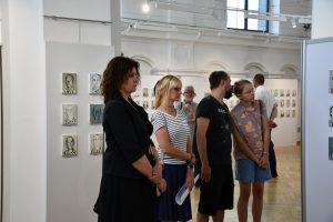 Publiczność zgromadzona na wernisażu wystawy portretów olejnych.