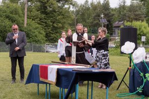 Ksiądz święci sztandar.