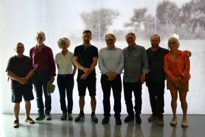 Grupa osób pozuje na tle ekspozycji muzealnej.