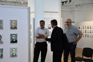 Trzech mężczyzn na tle ekspozycji.