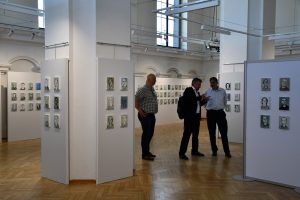 Trzech mężczyzn na tle ekspozycji.