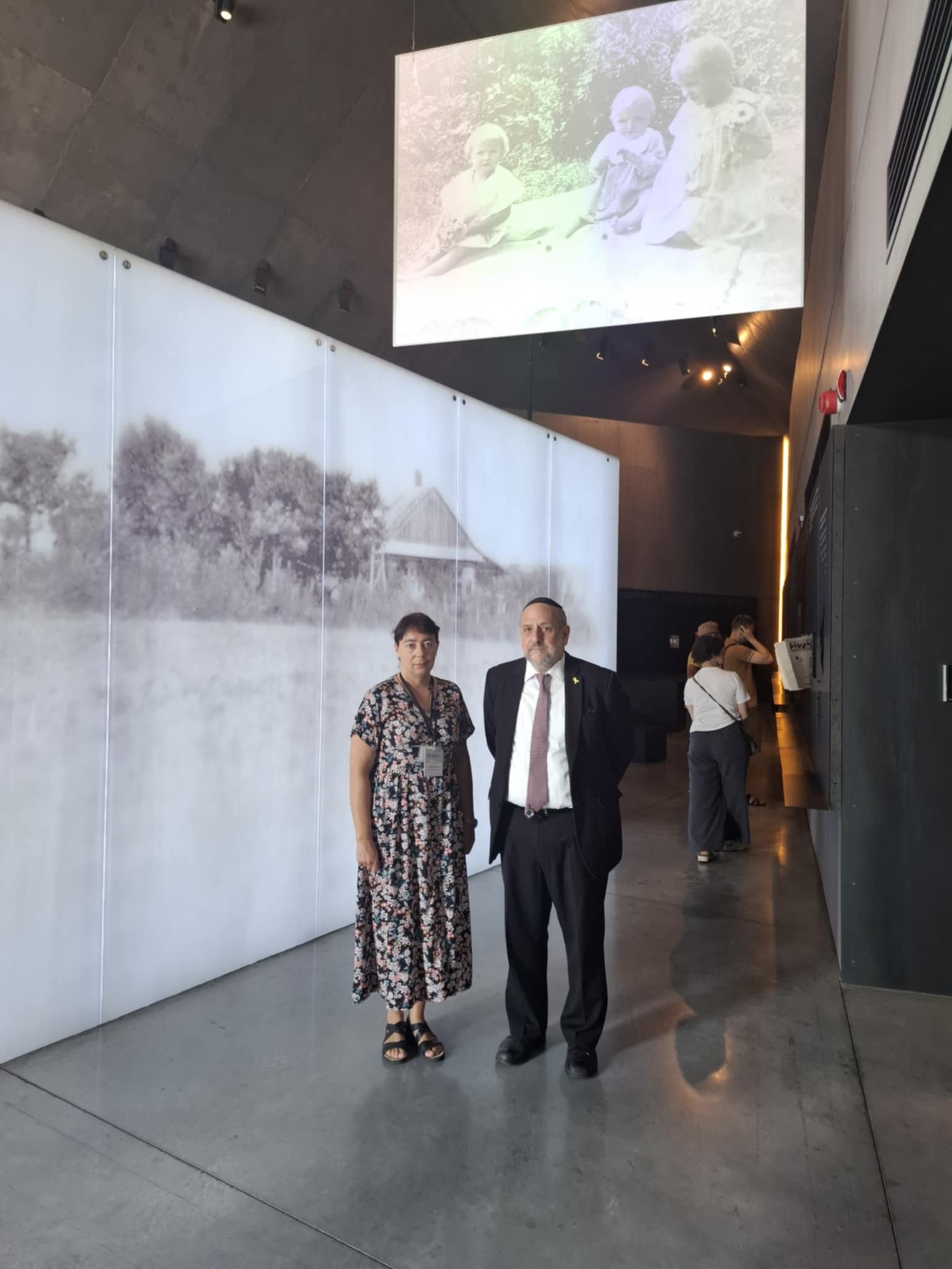 Dwie osoby - kobieta i mężczyzna, pozują do zdjęcia na tle ekspozycji muzealnej.