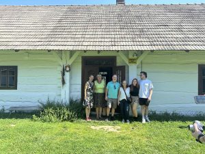 Goście pozują do zdjęcia przed Chałupą Szylarów.